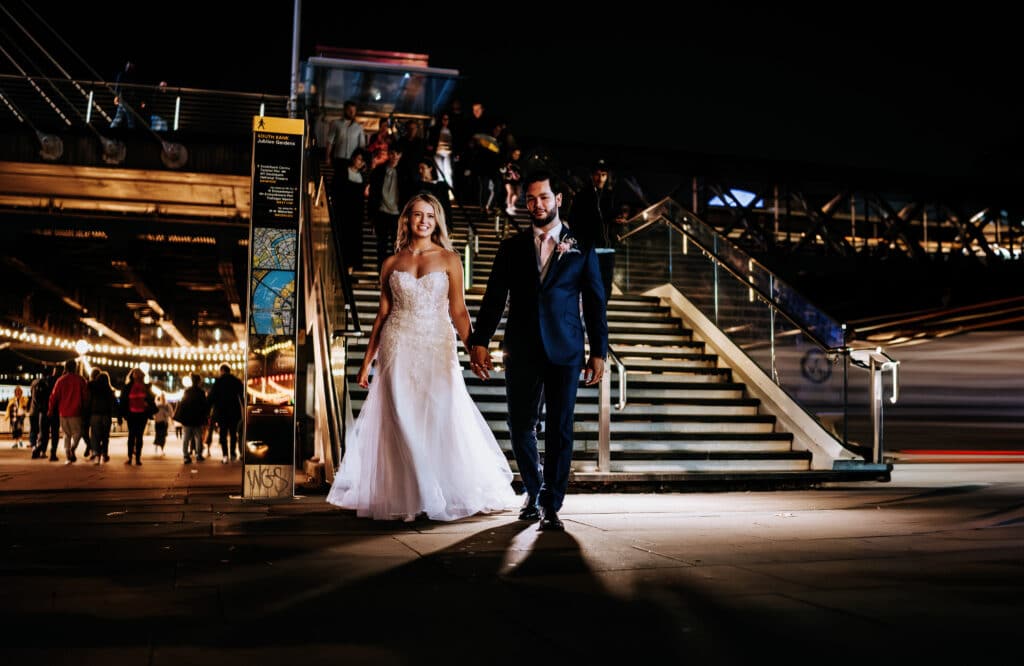 wedding ouple walking and holding hands at night near stairs Steve Bridgwood Photography 6