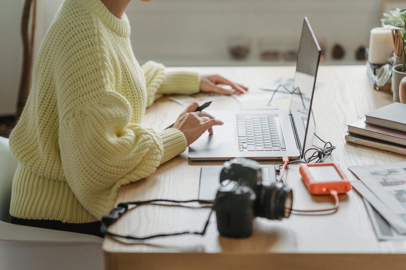 crop unrecognizable female photographer surfing netbook while sitting at table with photo camera and graphic tablet during work in light room 7014929 scaled e1777331292547